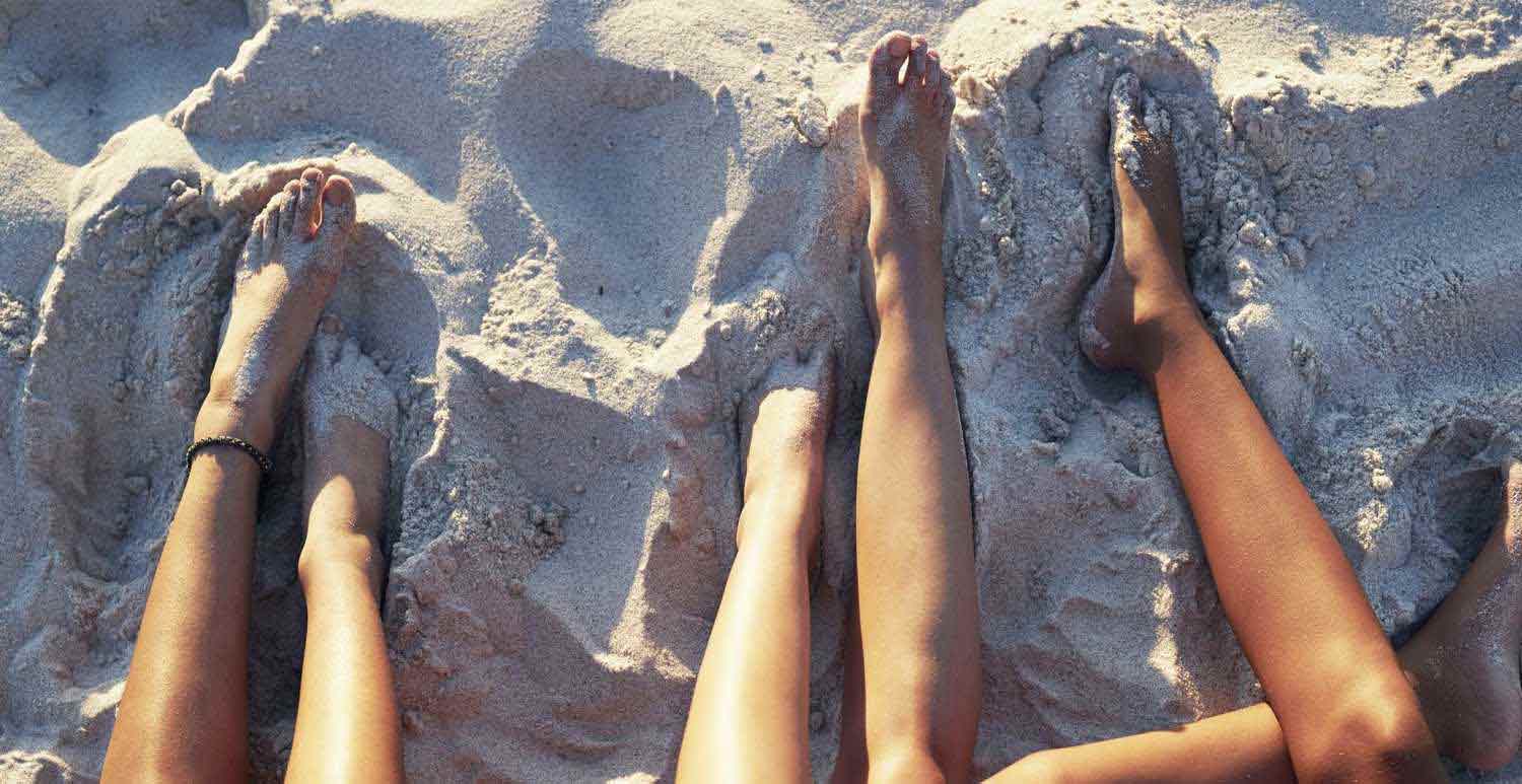 People's legs at a beach